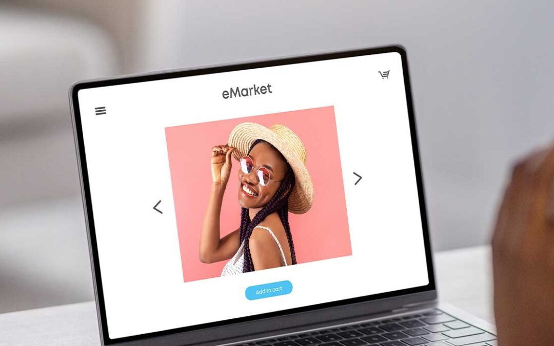 A person sits at a table with a cup of coffee, using a laptop displaying an online shop page featuring a woman in a hat and sunglasses posing against a pink background. The person is also talking on the phone.